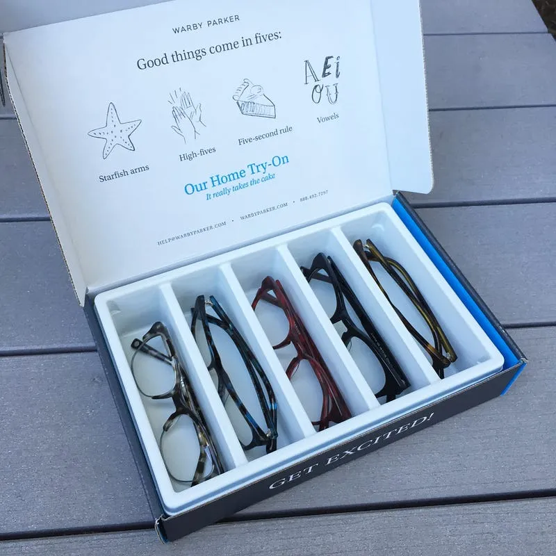 An open Warby Parker Home Try-On box holding five pairs of glasses